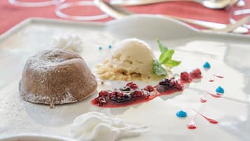 A dessert plate with a chocolate cake, ice cream, berries, and whipped cream.