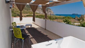A balcony with a wooden floor, a white bathtub, and a table with chairs. - Klelia Beach Hotel - All Inclusive (Zakynthos)