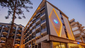 A multi-story hotel with balconies, a stone facade, and a prominent sign for the hotel. - Fatih Hotel Kleopatra (Alanya)