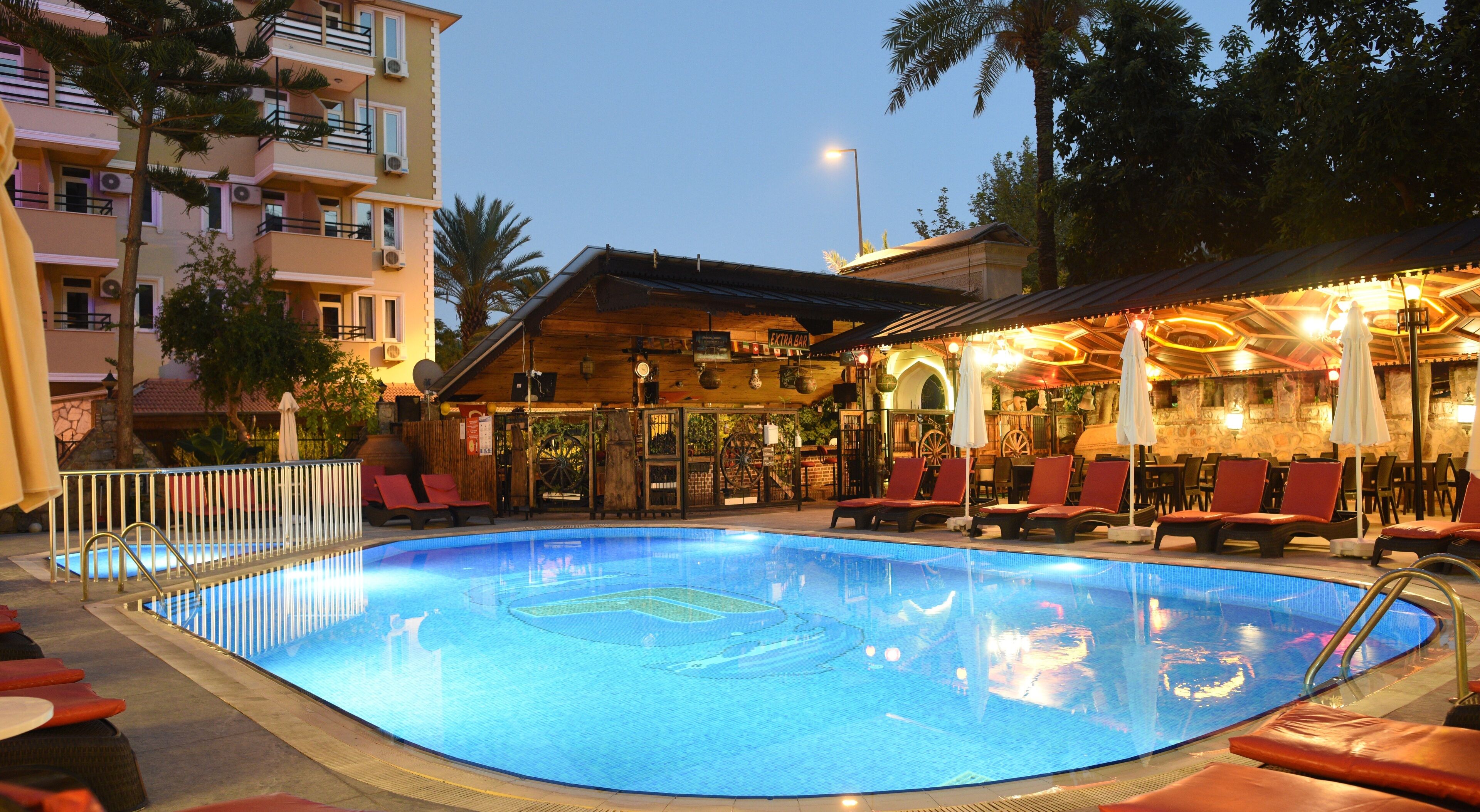 A swimming pool with lounge chairs and a bar area.
