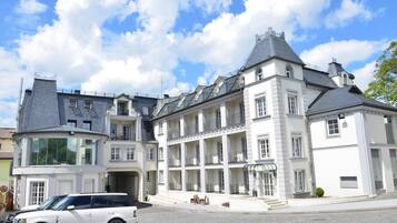 A large, multi-story building with a classic architectural style, featuring a central courtyard and multiple balconies.