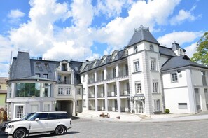 A large, multi-story building with a classic architectural style, featuring a central courtyard and multiple balconies. - Kavalier Boutique Hotel (Lviv)