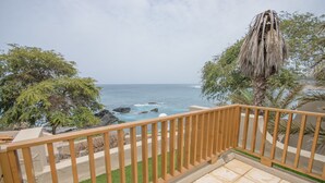 A balcony with a view of the ocean and rocky shoreline. - Hotel Oásis Atlântico Praiamar (Praia)