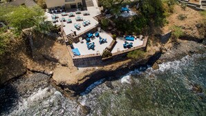 An aerial view of a coastal property with a patio area featuring outdoor seating and a pool. - Hotel Oásis Atlântico Praiamar (Praia)