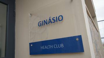 En skylt med texten ”GINÁSIO HEALTH CLUB” på en byggnadsvägg.