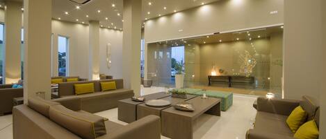 A modern living room with a sectional sofa, a coffee table, and a glass partition.