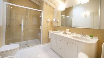 A modern bathroom with a glass-enclosed shower, a double sink vanity, and a large mirror.