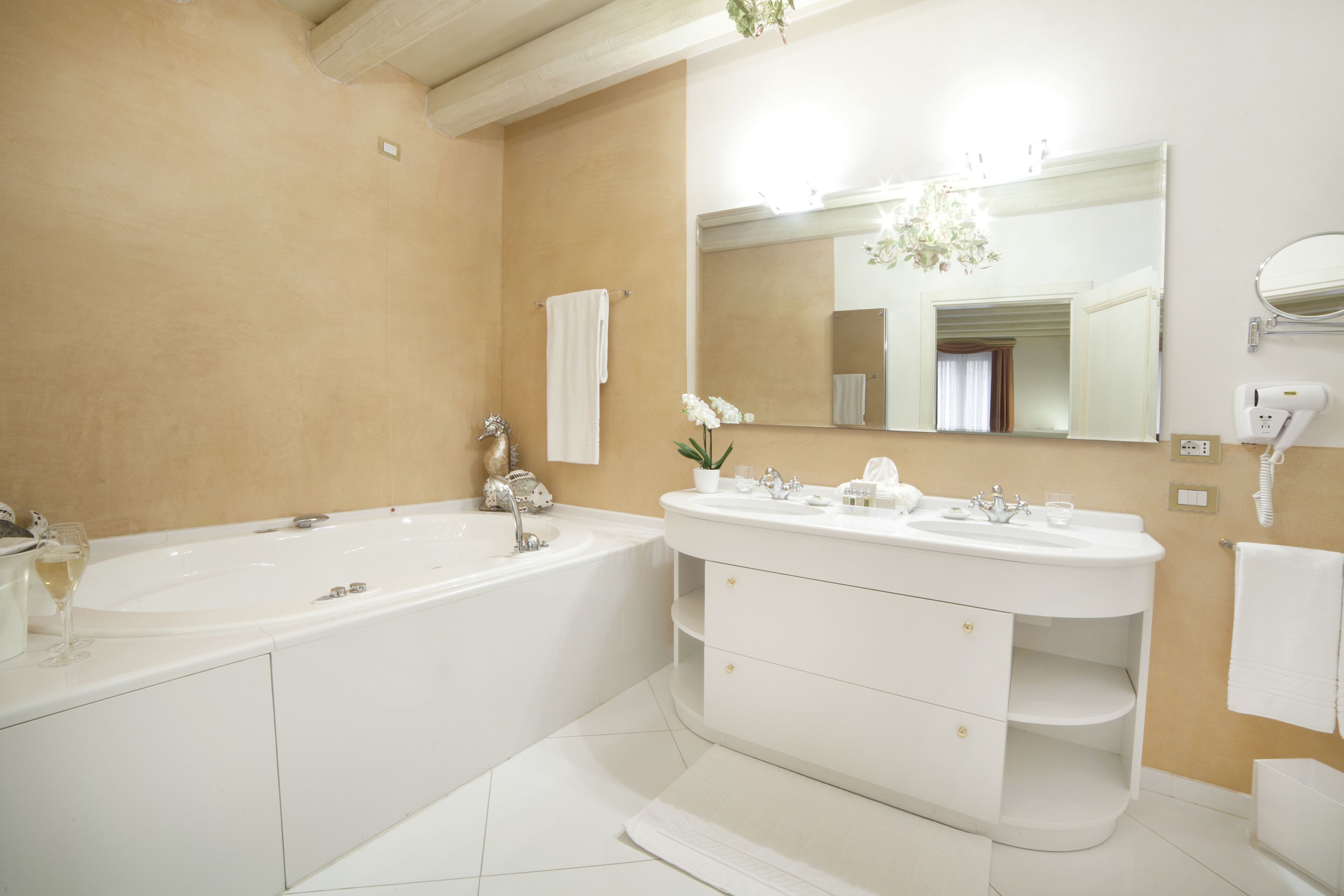 Une salle de bain moderne avec une grande baignoire, un meuble-lavabo à deux vasques et un grand miroir.
