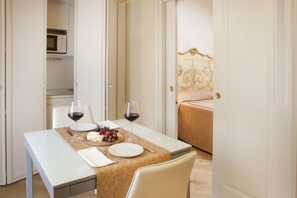 A dining area with a table set for two, including wine glasses, plates, and a fruit platter. - Relais Fra' Lorenzo (Verona)
