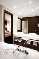 Un bagno moderno con due lavabi, uno specchio grande e una zona doccia separata.