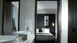 A modern bathroom with a large sink, a mirror, and a toilet. - Hotel Duo (Paris)
