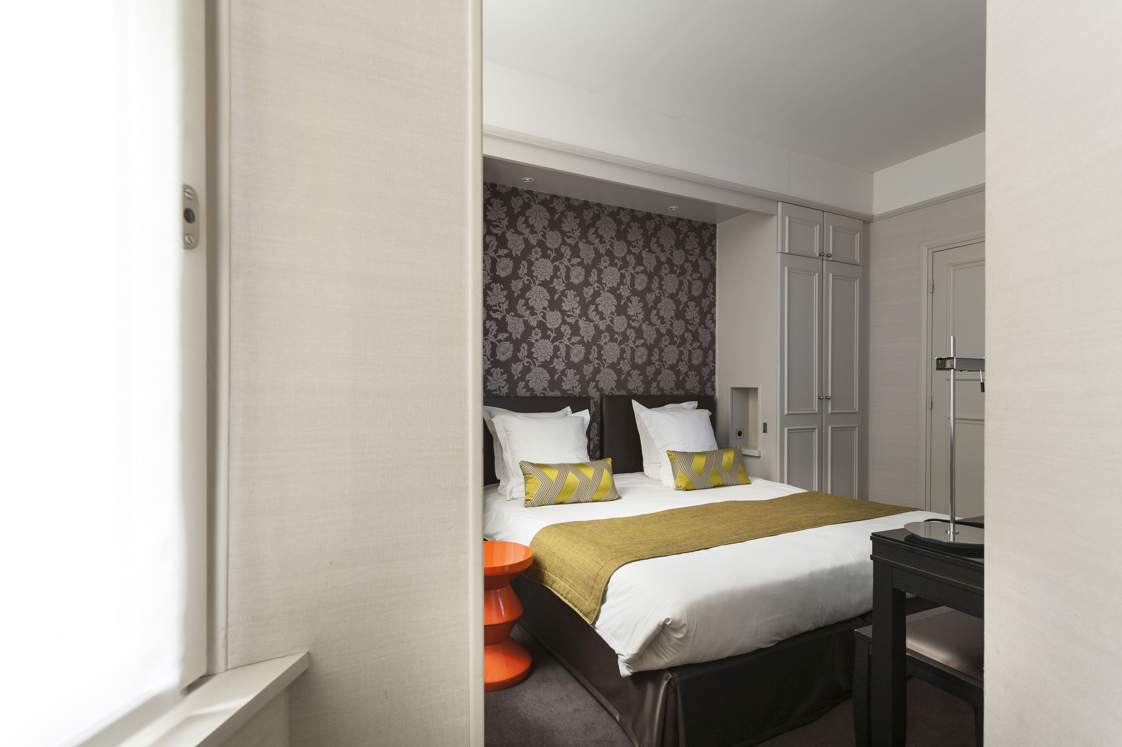 Une chambre d’hôtel avec un lit, un bureau et une armoire.