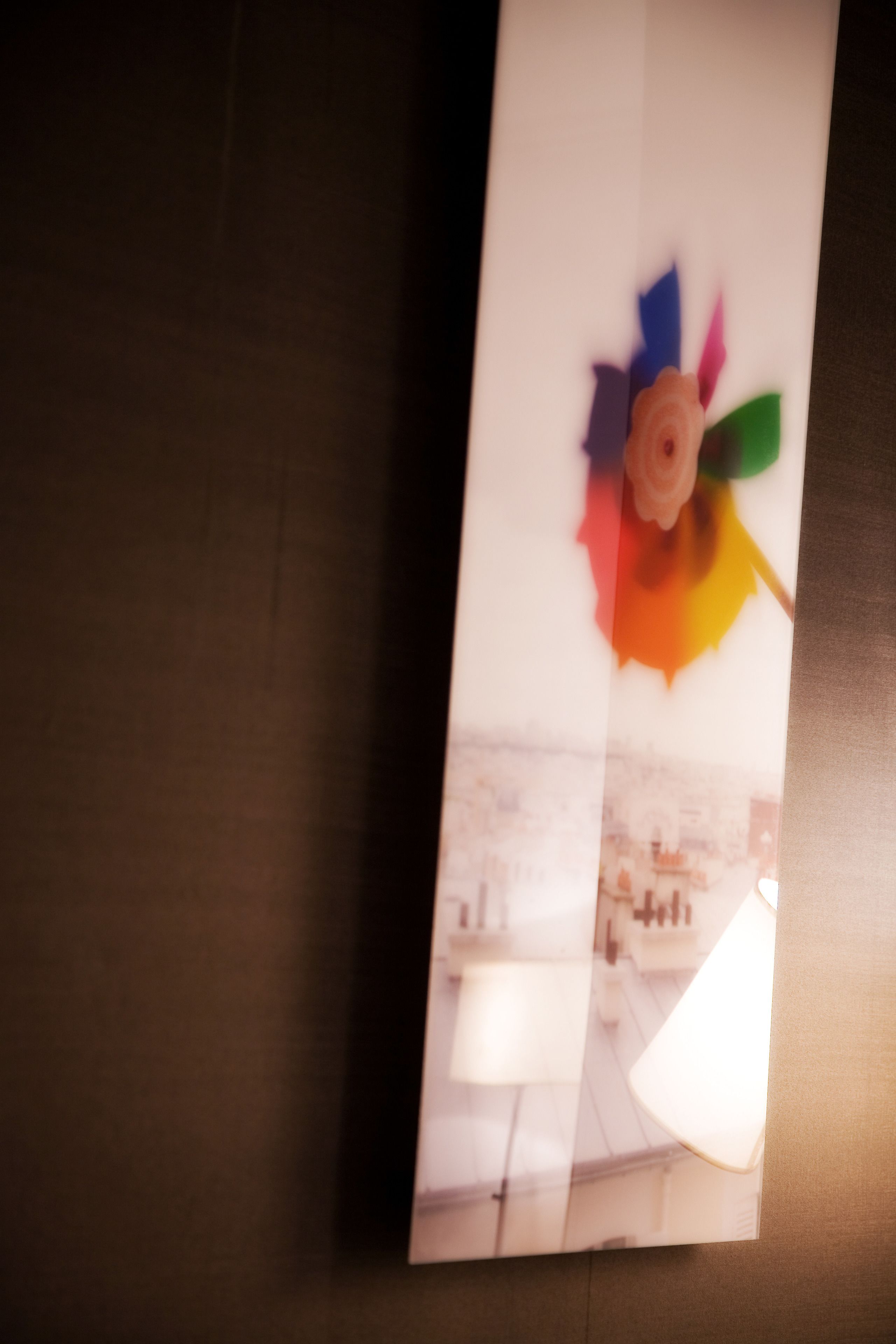 A pinwheel decoration with a flower in the center, mounted on a wall.