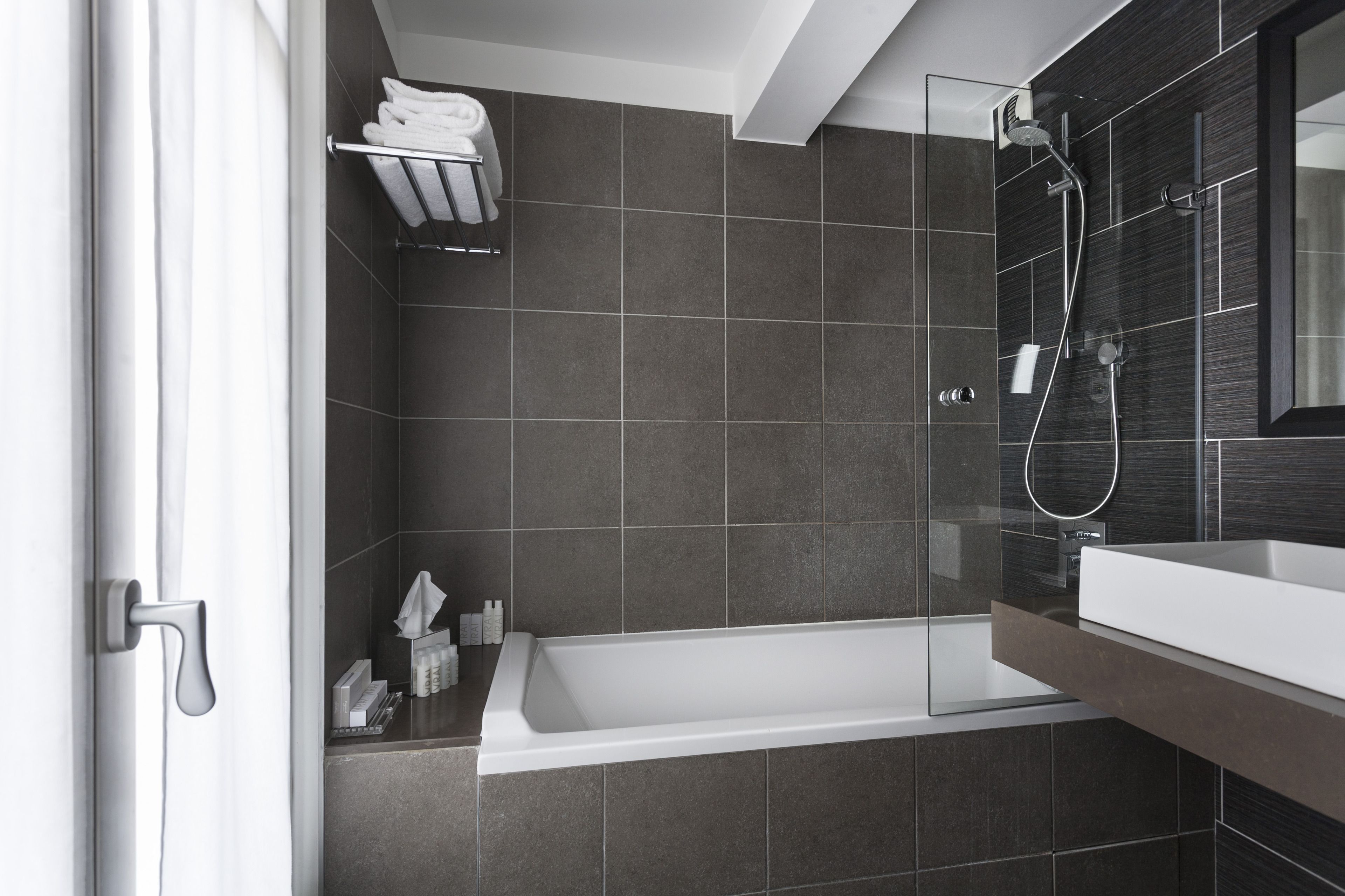A modern bathroom with a bathtub, a glass shower enclosure, and a vanity with a sink.