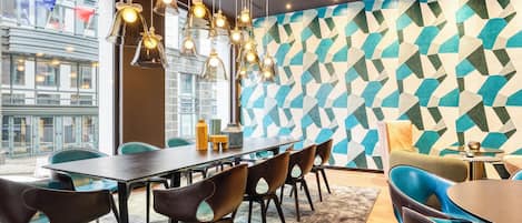 A modern conference room with a geometric patterned wall, a long table, and several chairs.