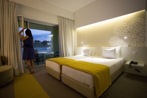 A hotel room with a bed, a desk, and a view of the outdoors. - Monte Filipe Hotel & Spa (Nisa)