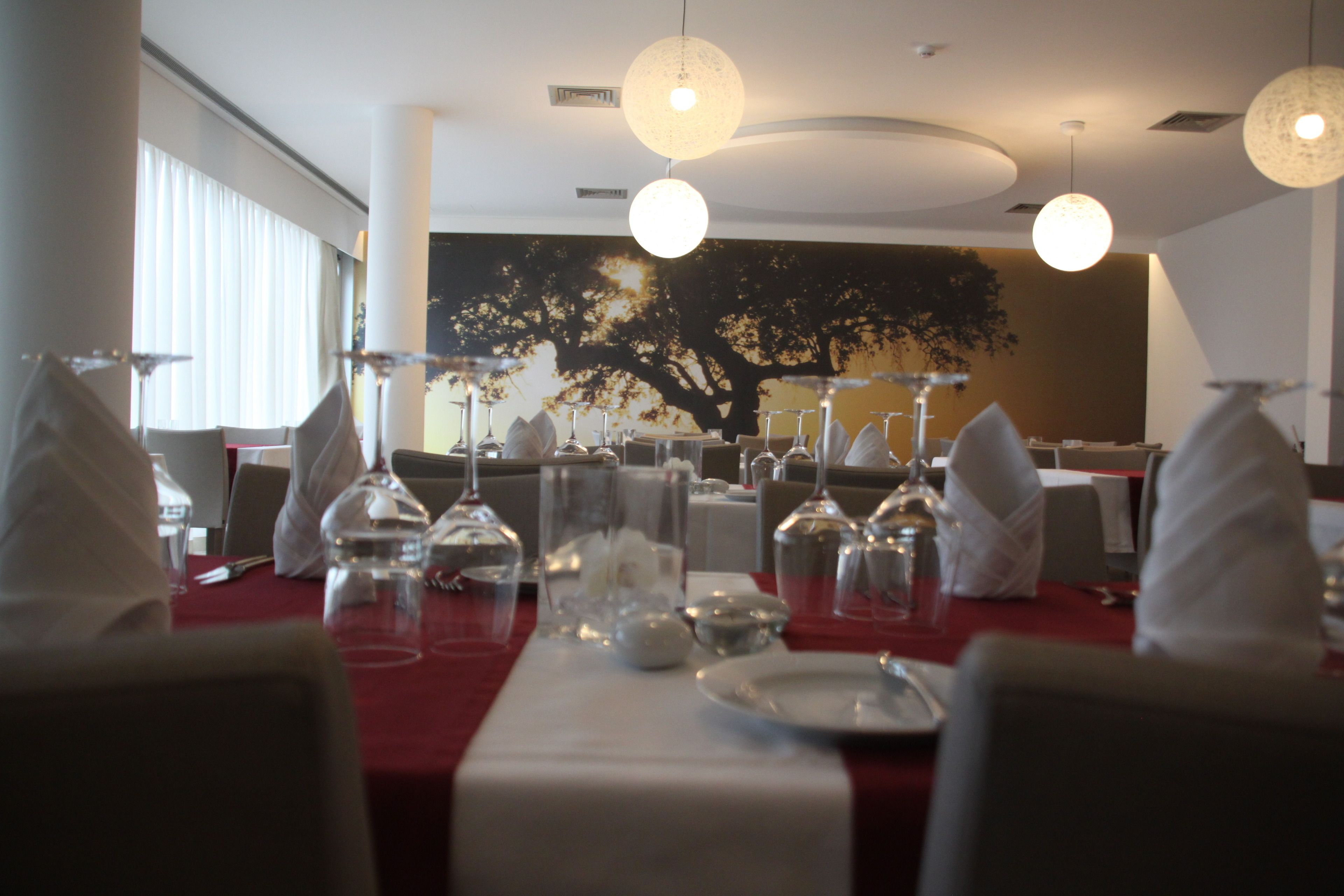 A restaurant with tables set for dining, featuring clear glassware and white napkins.