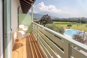 Enjoy a peaceful retreat with a balcony overlooking a serene garden and distant mountain views.