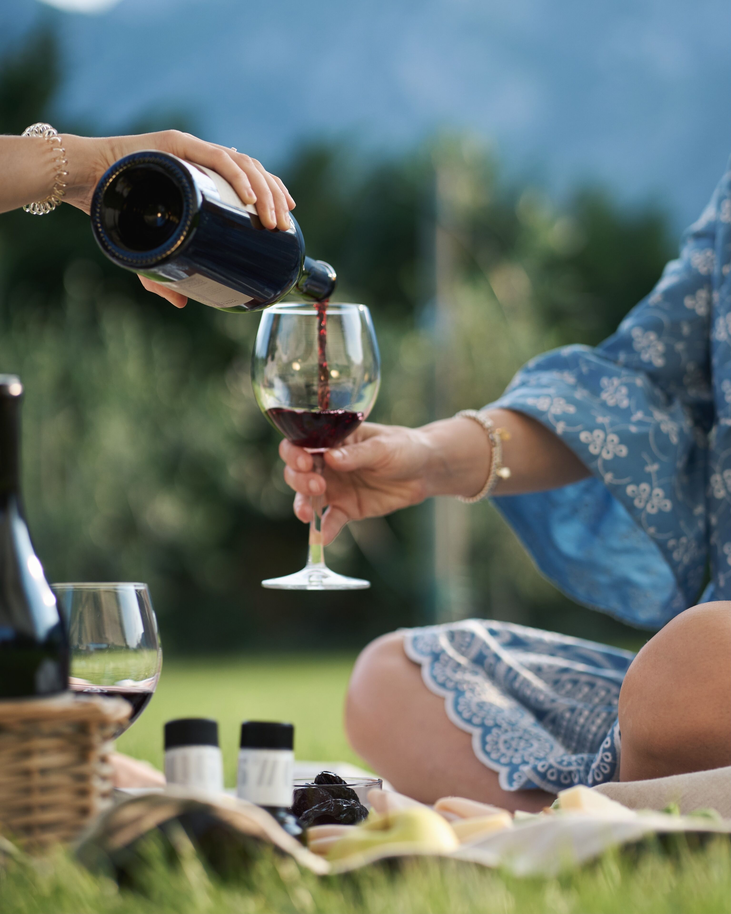 A person pouring wine into a glass.