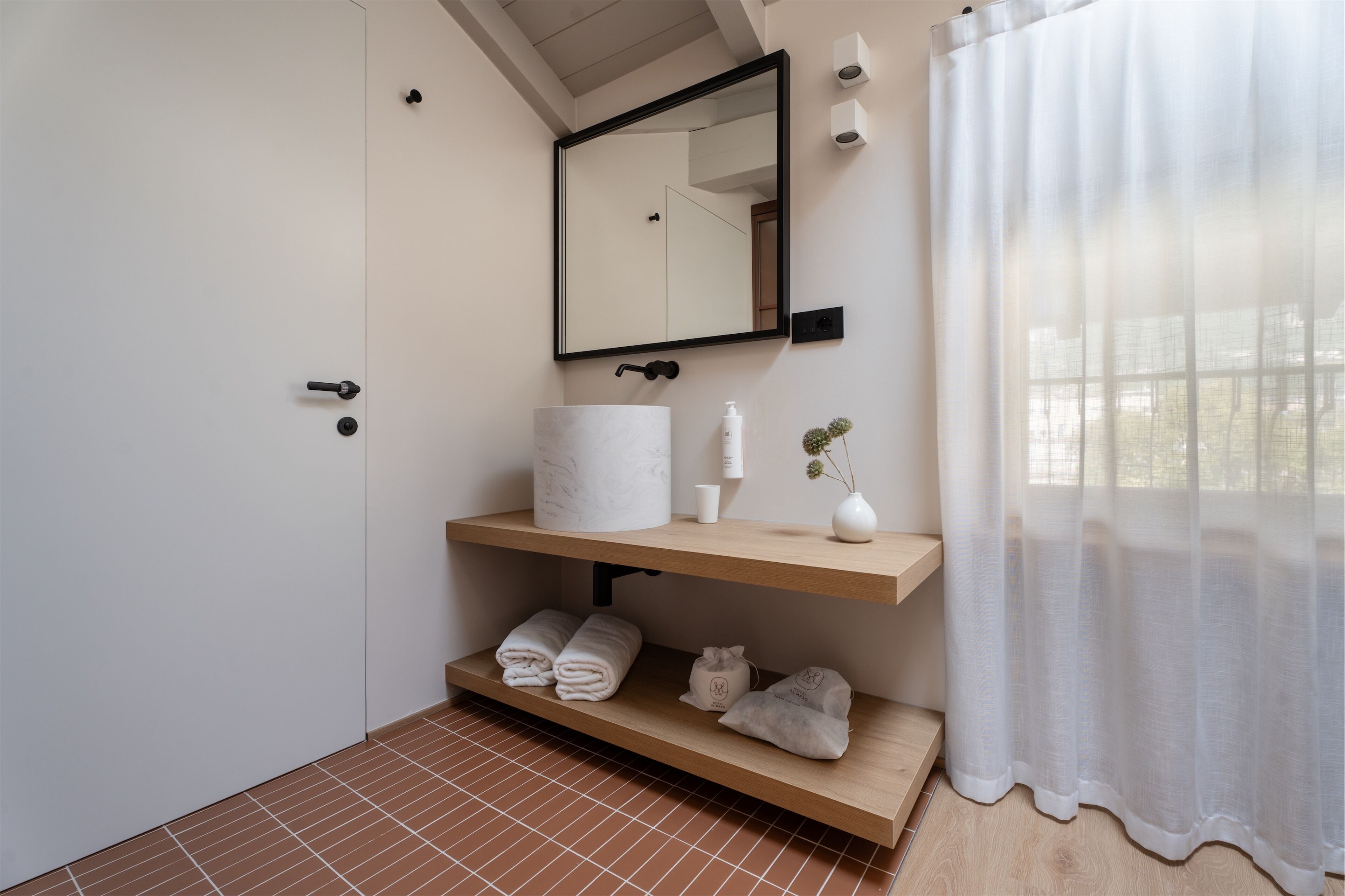 Une salle de bain avec un lavabo blanc, un miroir et un espace pour ranger les serviettes.