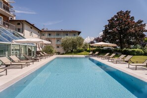 Relax by the pool surrounded by lush greenery and modern architecture.