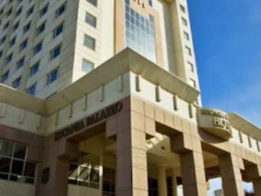 A multi-story building with a prominent entrance and a sign that reads "SLA".