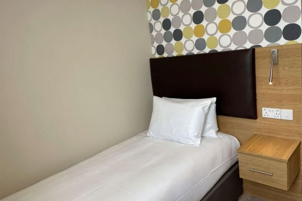 Escritorio, cortinas blackout y tabla de planchar con plancha
