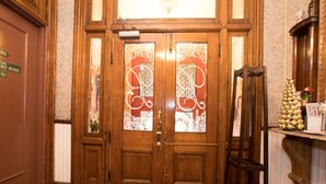 A wooden double door with glass panels and a brass handle. - Biltmore Suites Hotel (Baltimore)