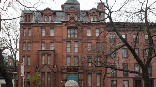 A large red brick building with a green awning and a sign that reads "Biltmore Hotel." - Biltmore Suites Hotel (Baltimore)