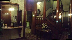 A traditional interior with a wooden staircase, a reception desk, and a mirror. - Biltmore Suites Hotel (Baltimore)