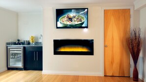 Una cocina moderna con televisión integrada, chimenea y refrigerador.