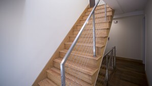 Una escalera de madera con barandillas metálicas en un interior moderno.