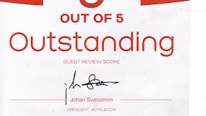 A red and white rating card for Trinity Hotel, rated 5 out of 5 for Outstanding guest reviews, signed by Johan Svanstrom, President of Hotels.com. - Trinity Hotel (Addis Ababa)