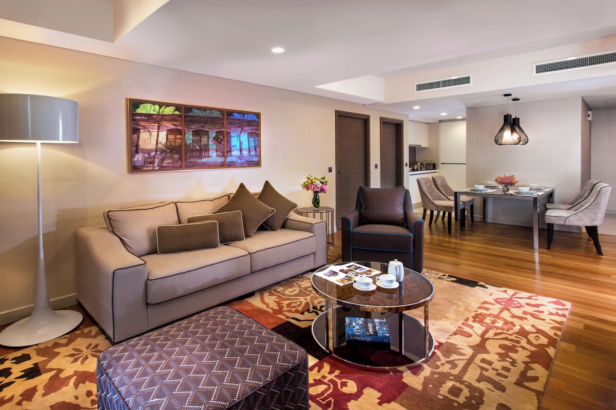 A modern living room with a sofa, armchairs, a coffee table, and a dining area with chairs and a table.