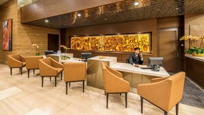 A reception area with a receptionist, a desk, and several chairs. - Ascott Sentral Kuala Lumpur (Kuala Lumpur)
