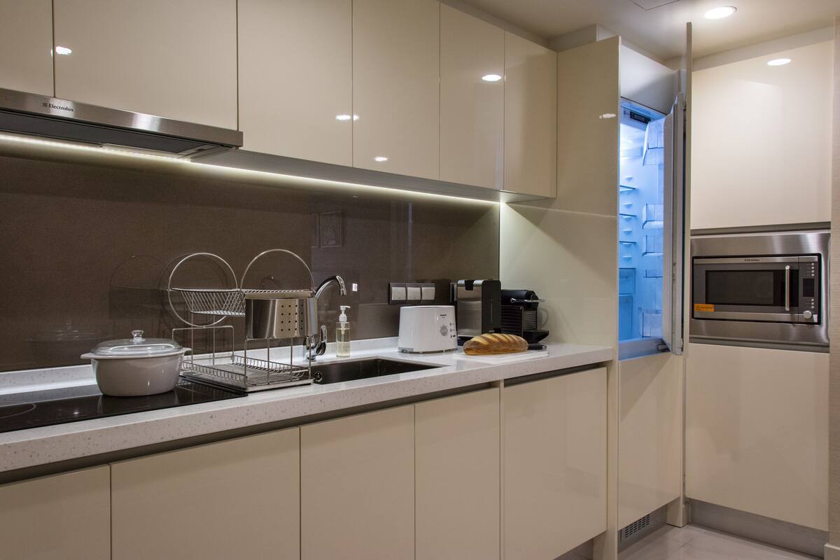 Una cocina moderna con electrodomésticos de acero inoxidable, horno integrado y microondas.