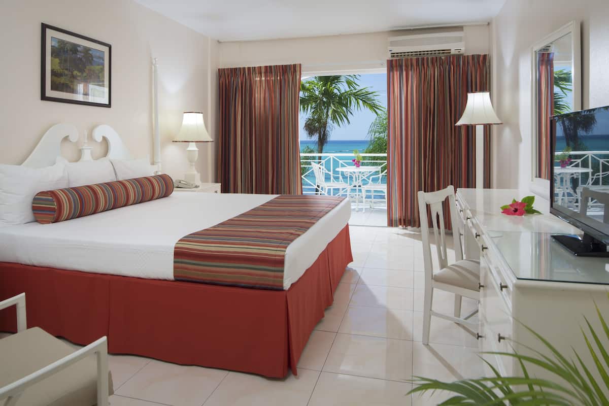 Habitación Deluxe, balcón, vista al océano | Tabla de planchar con plancha, wifi gratis y ropa de cama