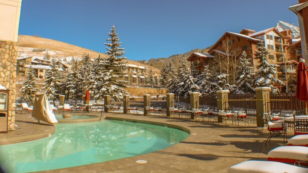 A resort with a swimming pool, snow-covered trees, and multiple buildings with balconies. - Grand Lodge by Crested Butte Lodging (Crested Butte)