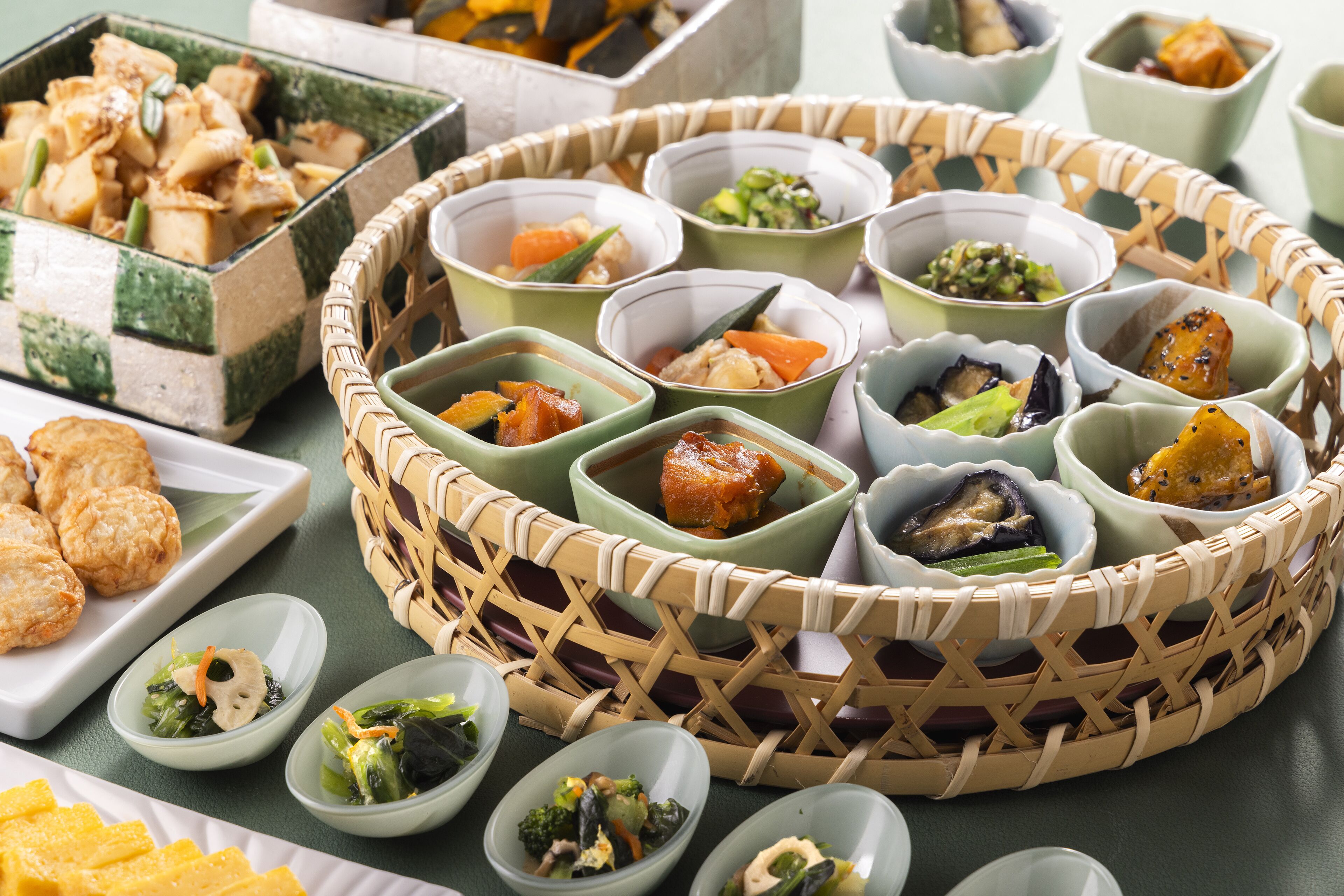 A variety of dishes arranged on a table, including bowls of different sizes and shapes, some containing vegetables and others with meat.