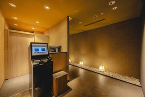 A reception area with a digital kiosk, wooden paneling, and a pebble-lined walkway.