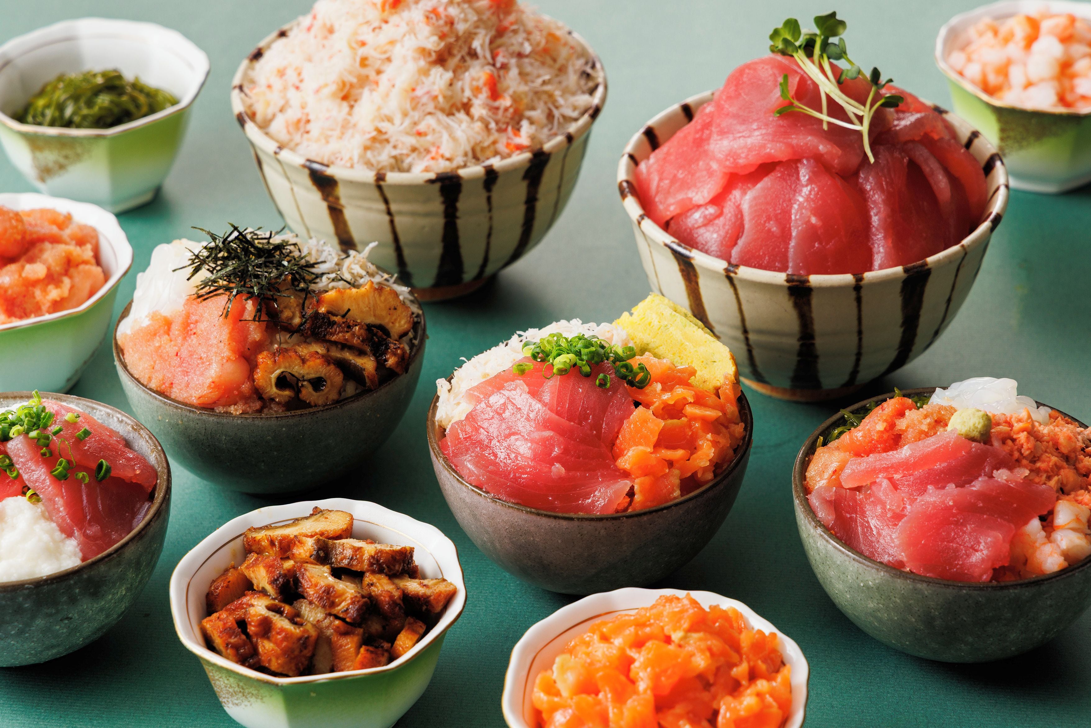 A variety of dishes, including sushi and rice, served in small bowls.