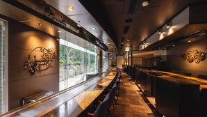 Una zona de dinar llarga i estreta, amb sostres alts i il·luminació moderna.