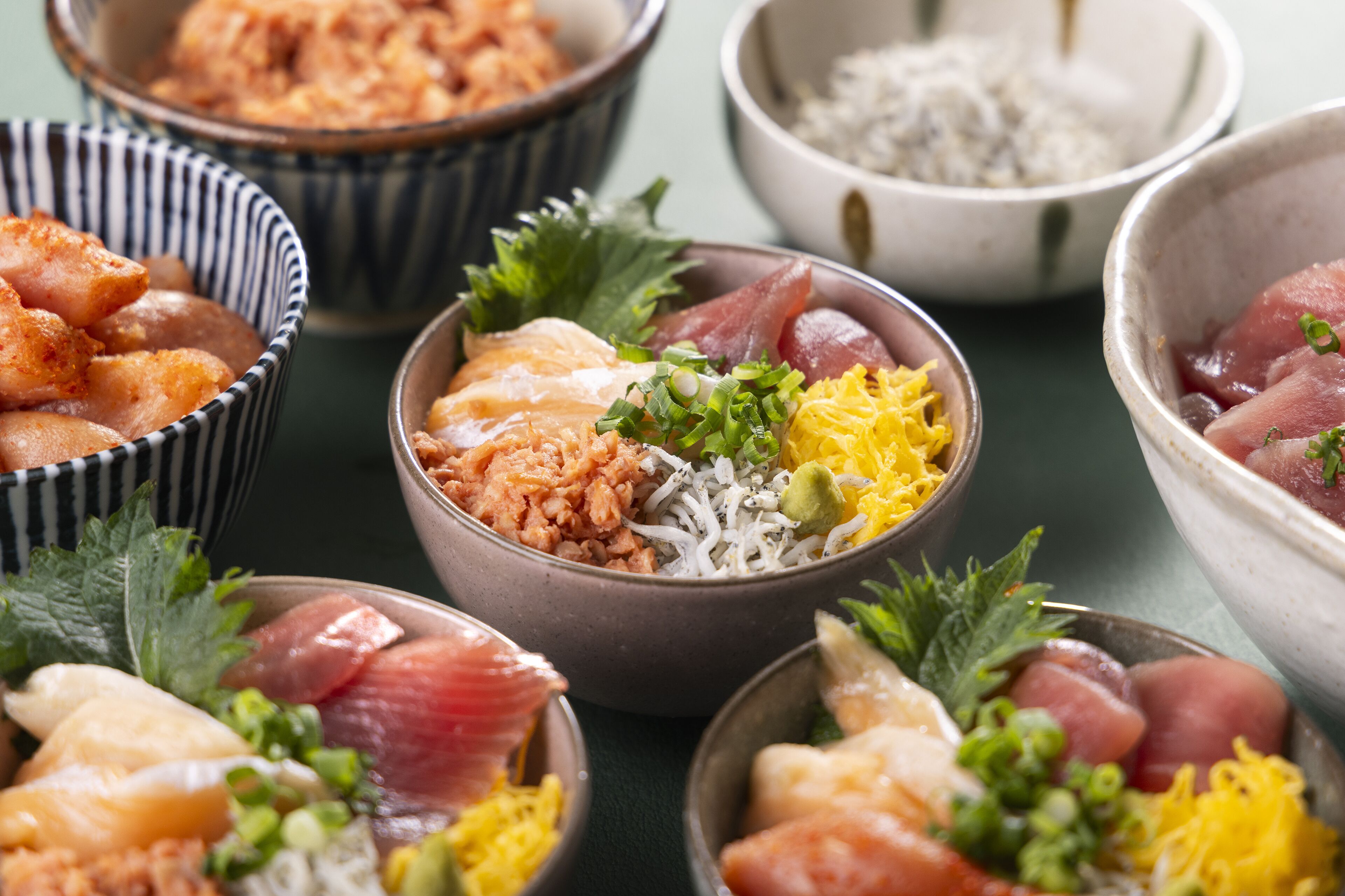 A variety of bowls containing different types of food, including seafood and rice.