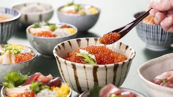 Diversos recipientes con diferentes tipos de comida, incluyendo huevos de pescado, adornos y otros ingredientes.