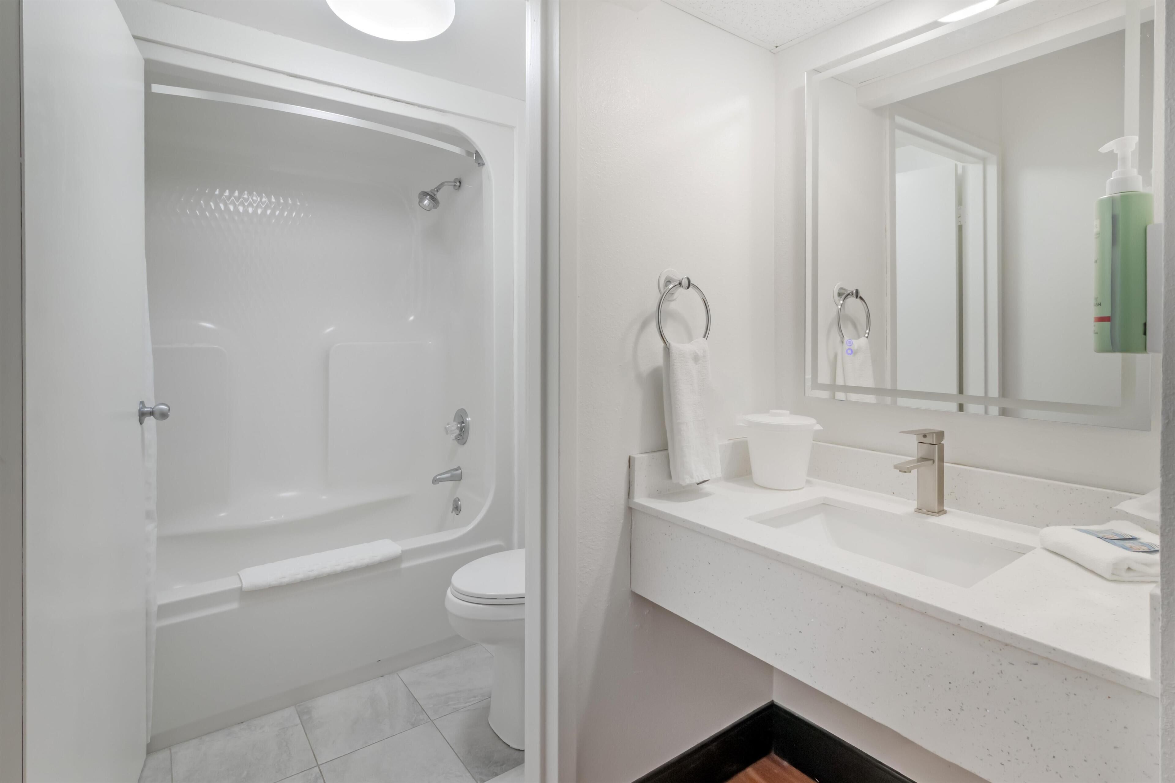 A modern bathroom with a bathtub, toilet, and sink.