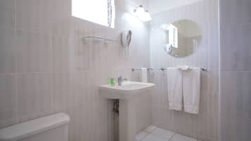 A bathroom with a toilet, sink, and towel rack.