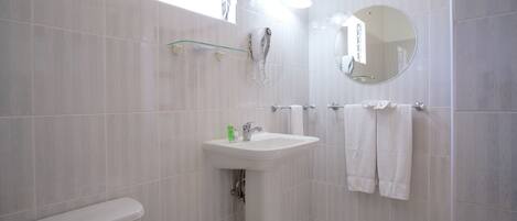 A bathroom with a toilet, sink, and towel rack.