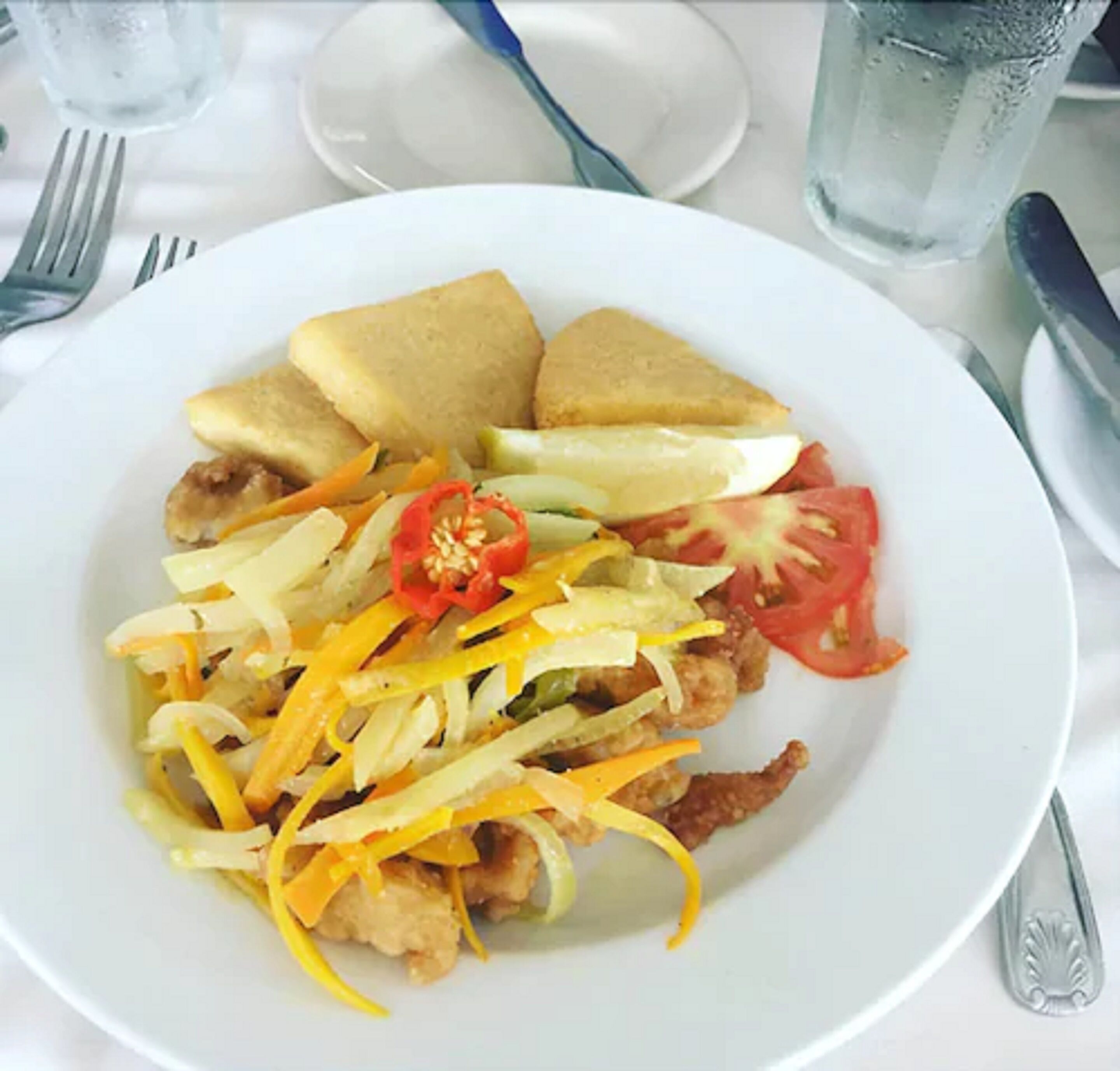 A plate of food with bread, vegetables, and a fried item.