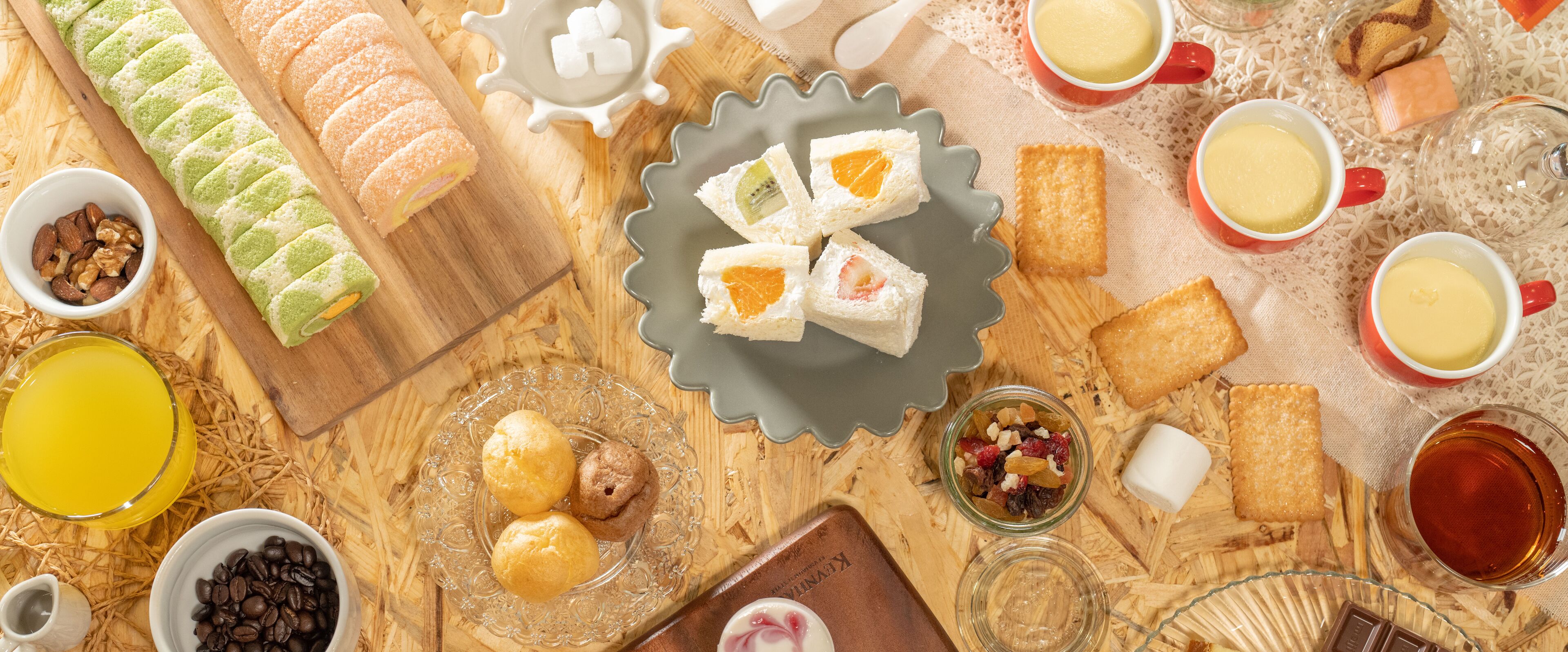 A variety of food items and beverages arranged on a wooden table.