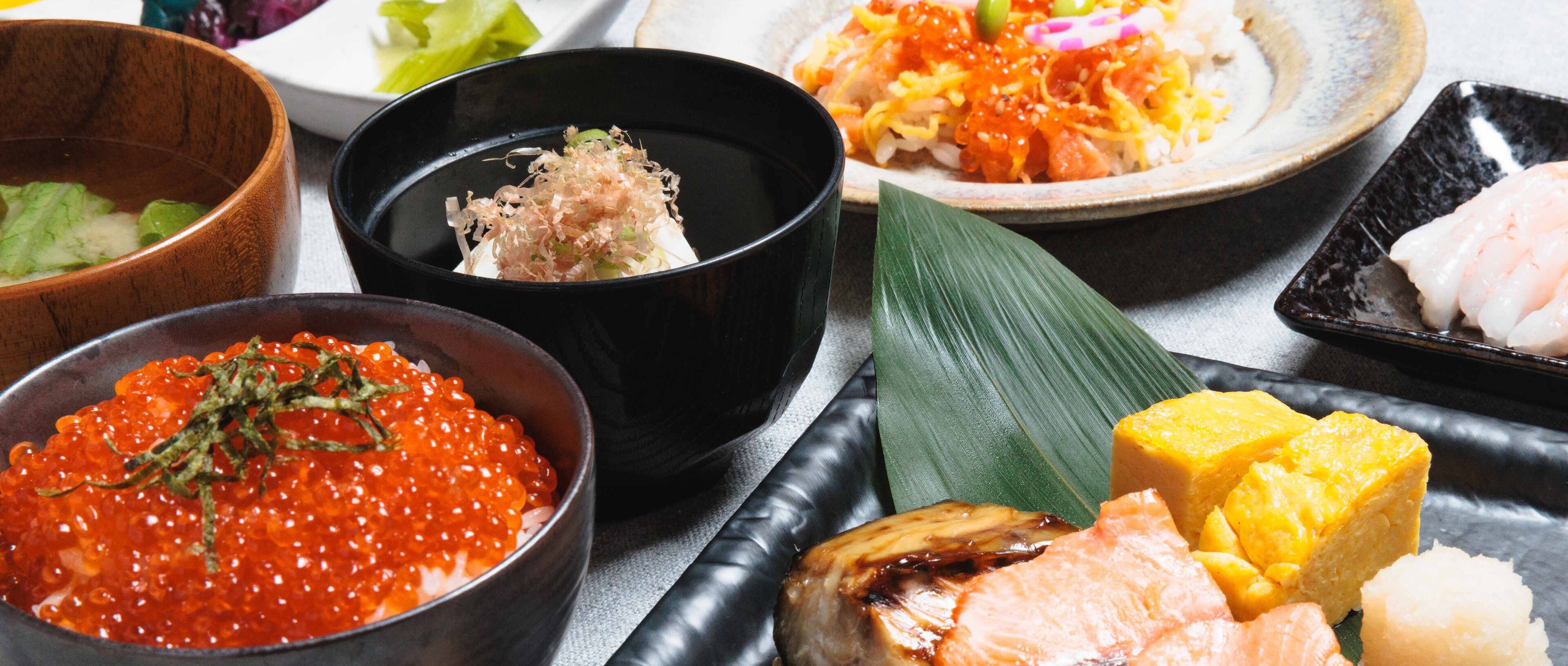 A variety of Japanese dishes including sashimi, rice, and pickled vegetables.